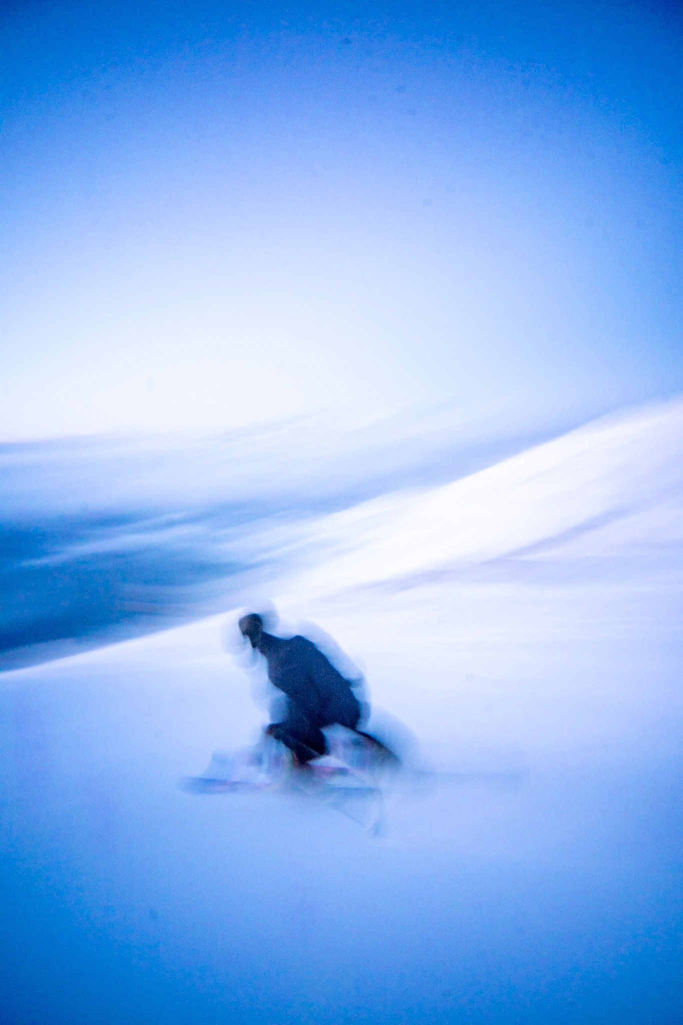 Skifahrer in Bewegungsunschärfe im blauen Abendlicht